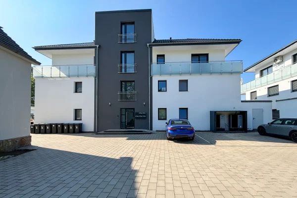 Mehrfamilienhaus Ringstraße Löhne – Frontansicht bei Sonnenschein mit Hofzufahrt und Parken