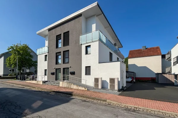Mehrfamilienhaus Bülowstraße Löhne – Schrägansicht mit Einfahrt und Glasbalkon im Obergeschoss